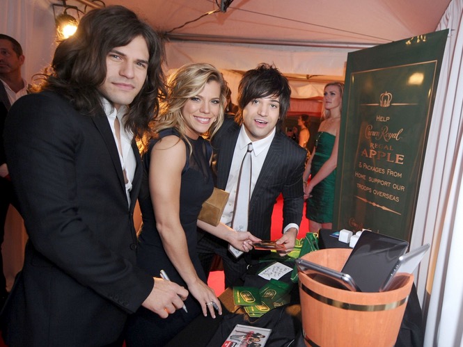 Reid Perry, Kimberly Perry, and Neil Perry of The Band Perry take a moment to pack a Crown Royal Regal Apple care package in effort to honor US troops overseas at the BLMG After Party on November 5, 2014 in Nashville, Tennessee. (Photo by Ilya S. Savenok/Getty Images for Crown Royal)