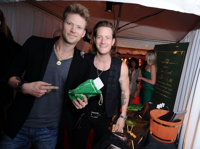 Brian Kelley and Tyler Hubbard of Florida Georgia Line take a moment to pack a Crown Royal Regal Apple care package in effort to honor US troops overseas at the BLMG After Party on November 5, 2014 in Nashville, Tennessee. (Photo by Ilya S. Savenok/Getty Images for Crown Royal)  